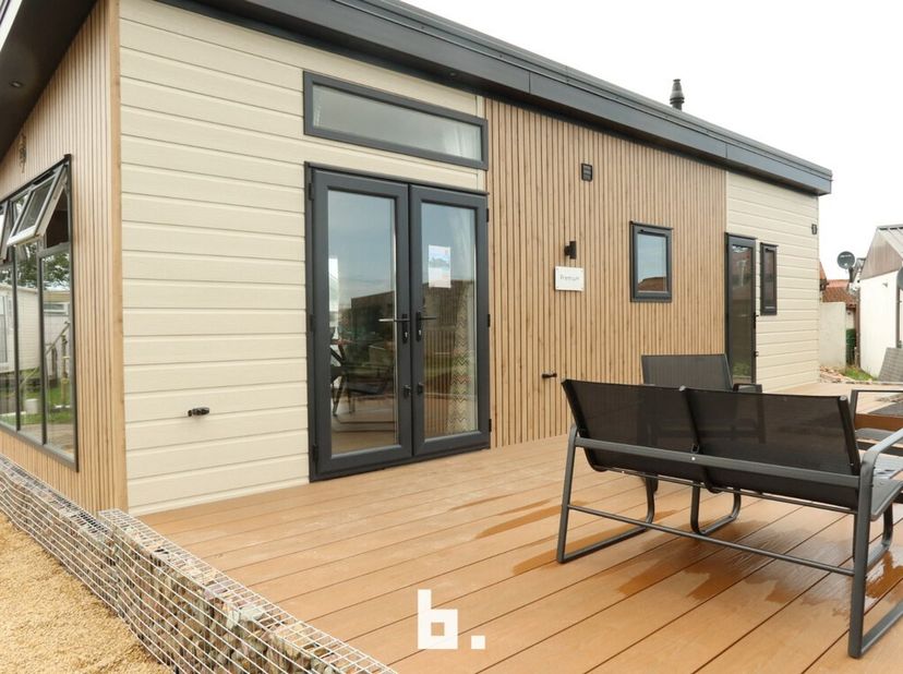 Nieuwe chalet (type Premium) op topligging vlak aan zee te Wenduine met mooie living met aansluitend terras, open ingerichte keuken, gasten toilet, ba