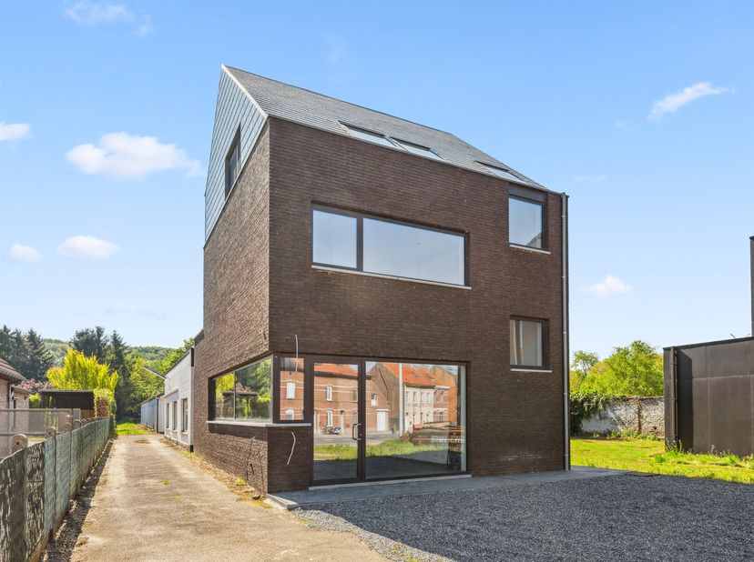 Découvrez ce bâtiment polyvalent et économe en énergie, composé d&#039;un espace commercial, d&#039;un appartement duplex et d&#039;un vaste entrepôt, situé sur un t
