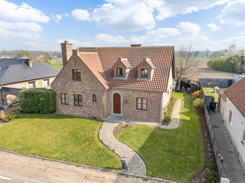 Deze aantrekkelijke woning met een opvallend statige gevel is gelegen langs Holt ter hoogte van nummer 33, op enkele honderden meters van het centrum
