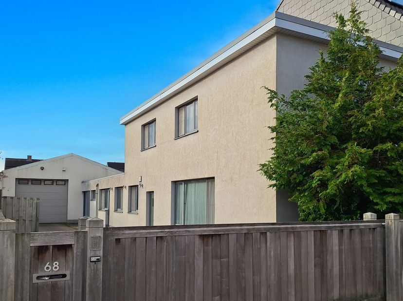Deze veelzijdige woning beschikt over een oprit met een automatische poort en een ruime werkplaats met eveneens een automatische poort, geschikt voor