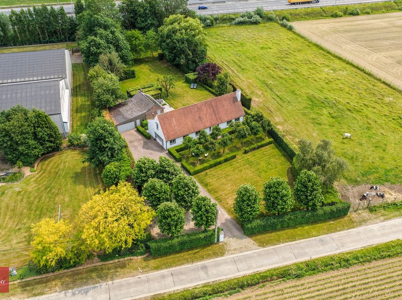 Landhuis bestaande uit inkomhal, zeer ruime living met open haard, eetplaats, ingerichte keuken met ontbijthoek, gelijkvloerse slaapkamer met badkamer