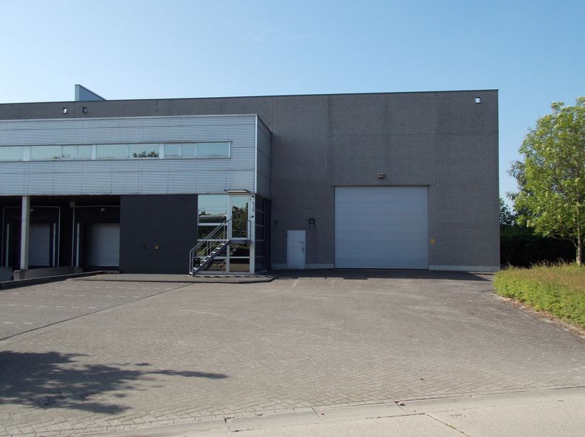 Opslagruimte 720m² met kantoor 91m² te huur in Mol. De opslagruimte bevindt zich in een multifunctioneel doorgangsgebouw gelegen aan het kanaal van Mo