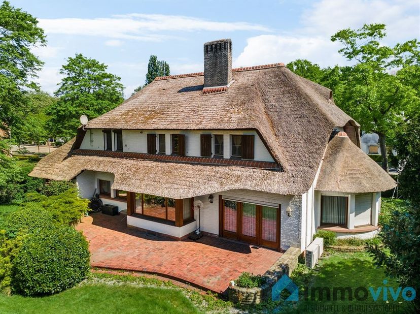 Op een absolute toplocatie in villawijk Den Brandt vinden we deze knappe rietgedekte villa op een zuid-gericht perceel van 1.120 m². Op nog geen 100 m