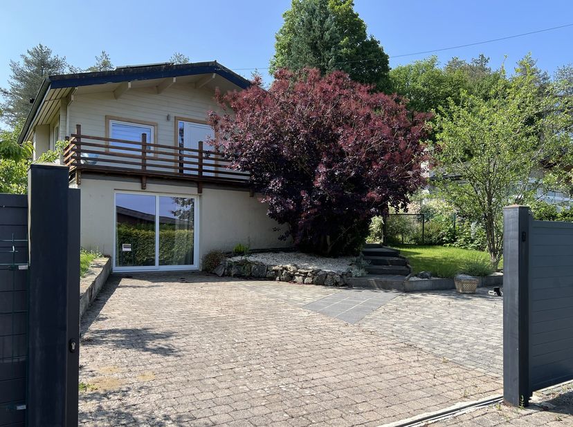 Située dans un environnement calme, cette habitation de type chalet, érigée sur un sous-bassement en maçonnerie, a bénéficié dune rénovation complète