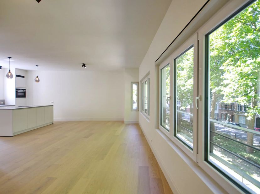 Hall d&#039;entrée avec vestiaire et toilette séparée, espace de vie avec cuisine full équipée avec îlot central, 2 chambres de ± 16m² et ± 14m², buanderie