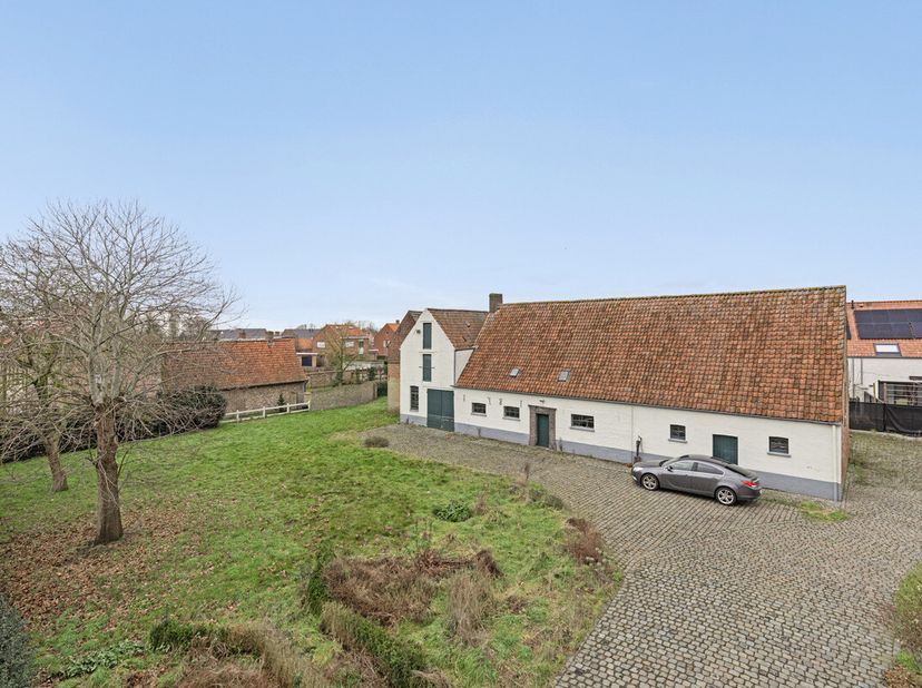 Deze te renoveren historische hoeve, gelegen op een royaal perceel van 1.338 m² in het pittoreske Jabbeke, combineert op harmonieuze wijze landelijke