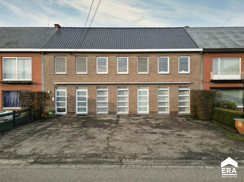 Appartementsblok met twee verhuurde appartementen en een centrale ligging nabij het centrum van Alken. Gelijkvloers appartement (181 m²): inkomhal met
