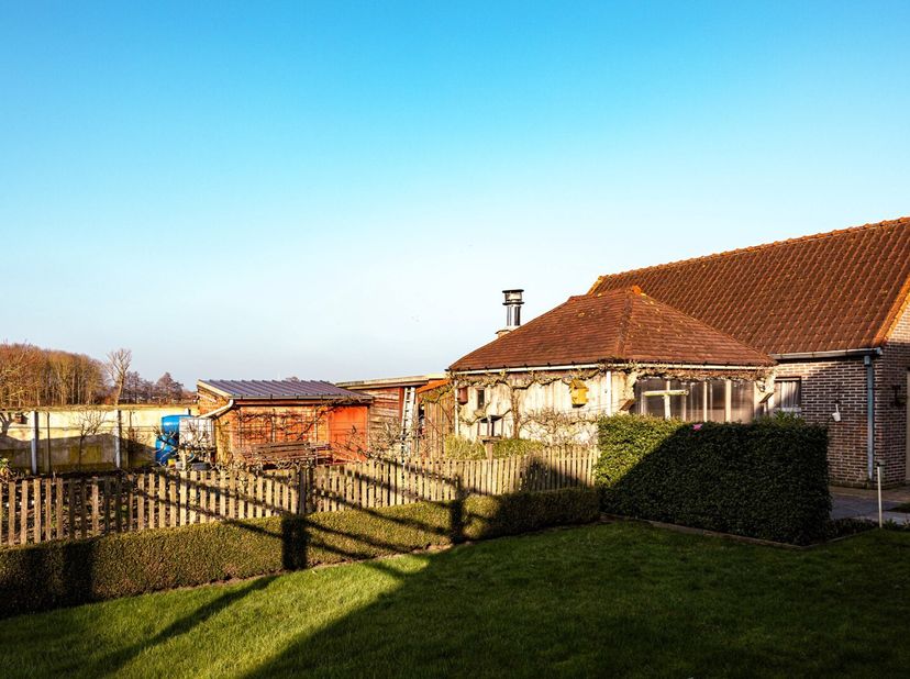 Open bebouwing op 1.215 m² met op het gelijkvloers inkom, leefruimte, recent vernieuwde keuken met granieten werkblad en alle toestellen, toilet, slaa