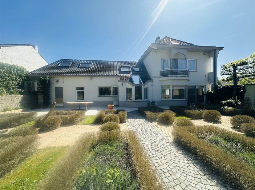 In het landelijke maar vlot bereikbare Montenaken vinden we deze klassieke villa met praktijkruimte en aangelegde tuin.   Montenaken ligt op 5 minuten