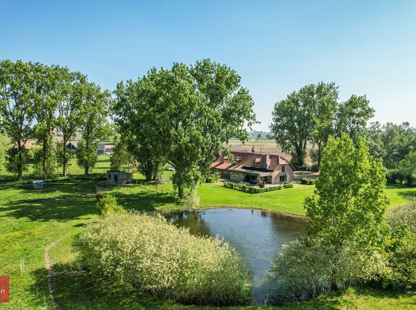 Landhuis vernieuwd in 2014, bestaande uit inkomhal, zeer ruime living met open haard en parket, volledig ingerichte keuken met eethoek, wasplaats (bij