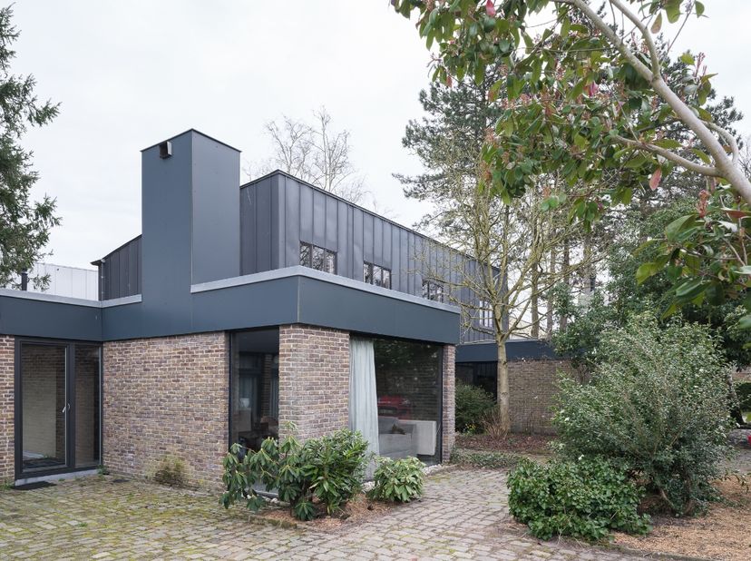 Merelbeke – Op te frissen, ruime architecturale woning (bvo 396 m2) met polyvalente mogelijkheden en bovengelegen zorgwoning op een groen perceel van