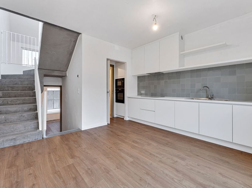 In het centrum van Kortrijk vinden we deze dynamische, splitlevel-stijl woning.<br />
Op het gelijkvloers vinden we een ruime inkomhal met fietsenberg