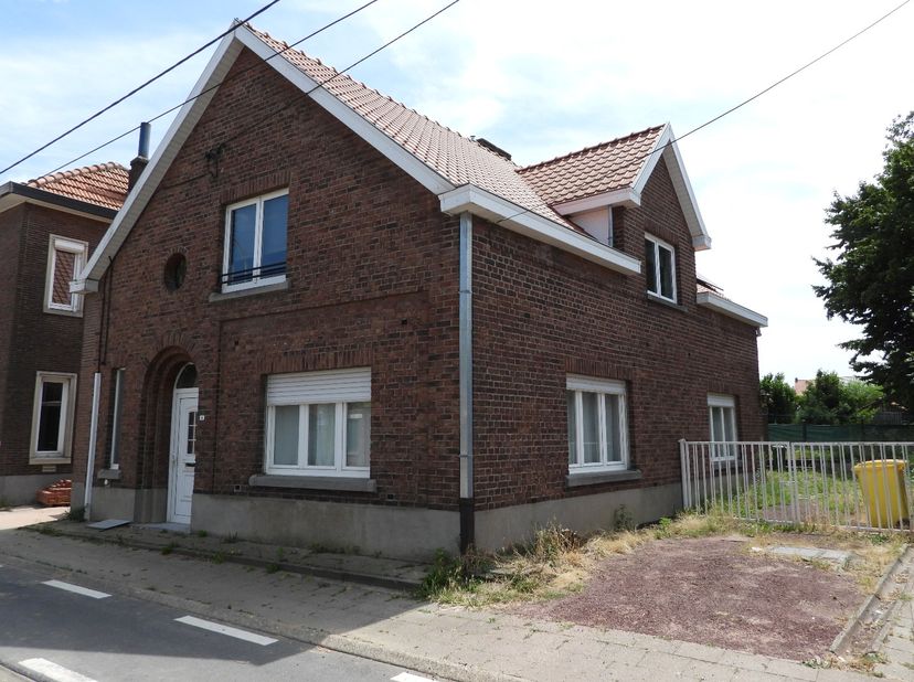 Woning : inkomhal, living, bureau, keuken, garage, op verdiep drie slaapkamres en één badkamer, buiten oprit, terras en gazonnetje