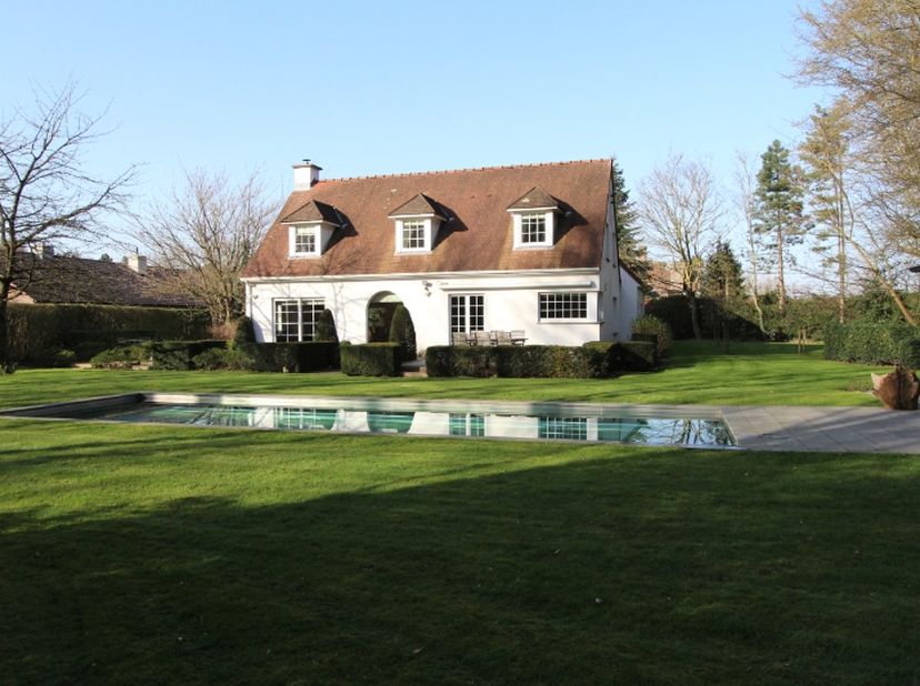 Tijdloze villa met vier slaapkamers, verwarmd inox zwembad en eiken poolhouse gelegen aan het bos Slotendries te Oostakker- Lourdes. Deze villa is gel