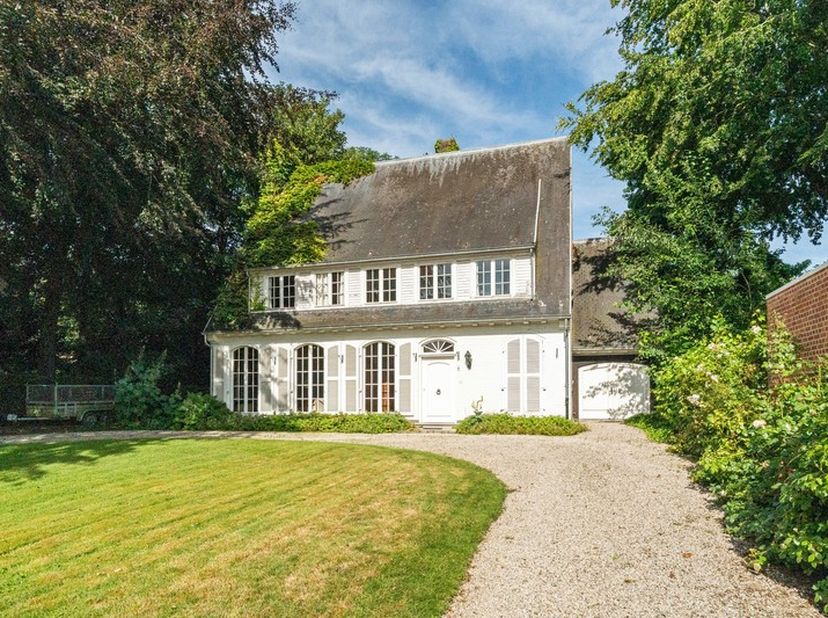 In een prachtige, groene omgeving vinden we deze karaktervolle villa met statige uitstraling en tal van mogelijkheden. De halvemaanvormige oprijlaan m