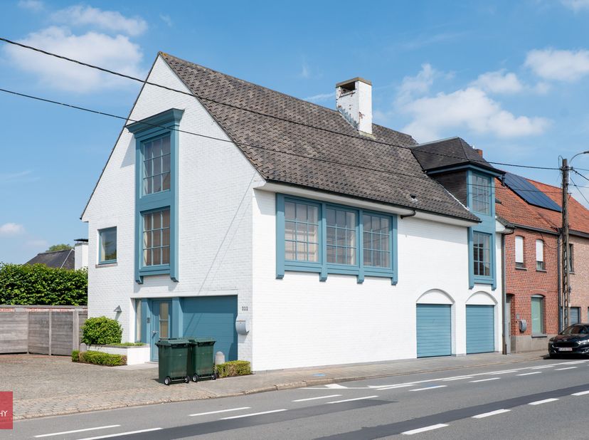 Ruime luxe - woning bestaande uit een inkomhall, wasberging, garages voor 3 wagens, kelder, op verdieping een lichtrijke living met open haard, ingeri