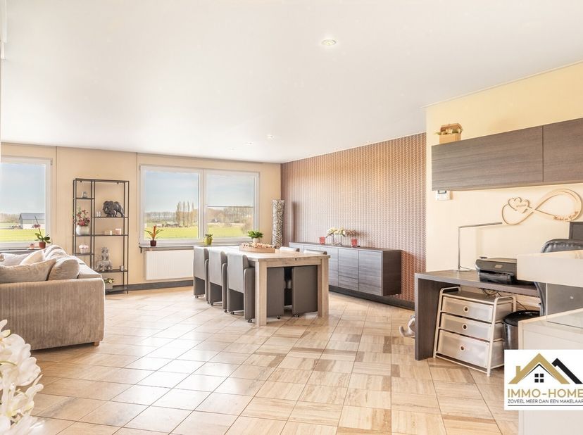 De eerder anonieme voorgevel van deze woning verbergt een ware parel. Via de riante inkomhal bereik je de eerste verdieping, waar zich de woon- en lee