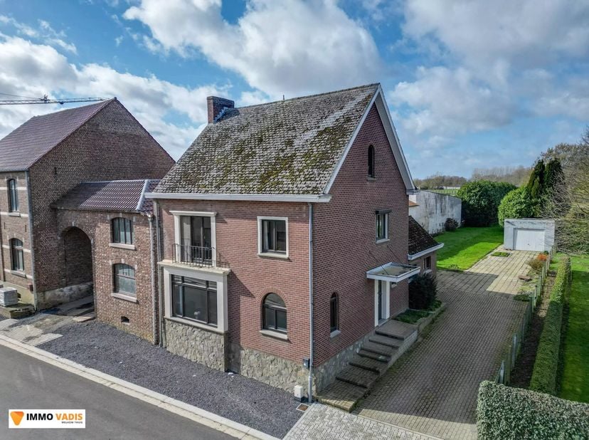Deze halfopen bebouwing, landelijk en uiterst rustig gelegen, beschikt over vier volwaardige slaapkamers en biedt tal van mogelijkheden om bijkomende