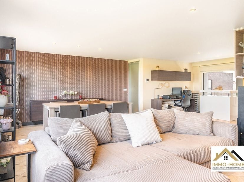 De eerder anonieme voorgevel van deze woning verbergt een ware parel. Via de riante inkomhal bereik je de eerste verdieping, waar zich de woon- en lee