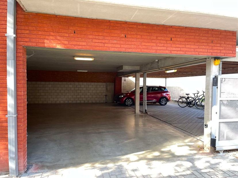 De staanplaats bevindt zich onder een carport en is bereikbaar via een afgesloten toegangspoort met code, wat zorgt voor extra veiligheid en privacy.<