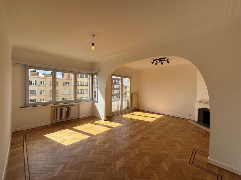 Licht appartement van 123 m² (EPB) in de wijk ULB<br />
Entreehal met ruime woonkamer van 34 m² met open haard en parketvloeren.<br />
Ingerichte keuk