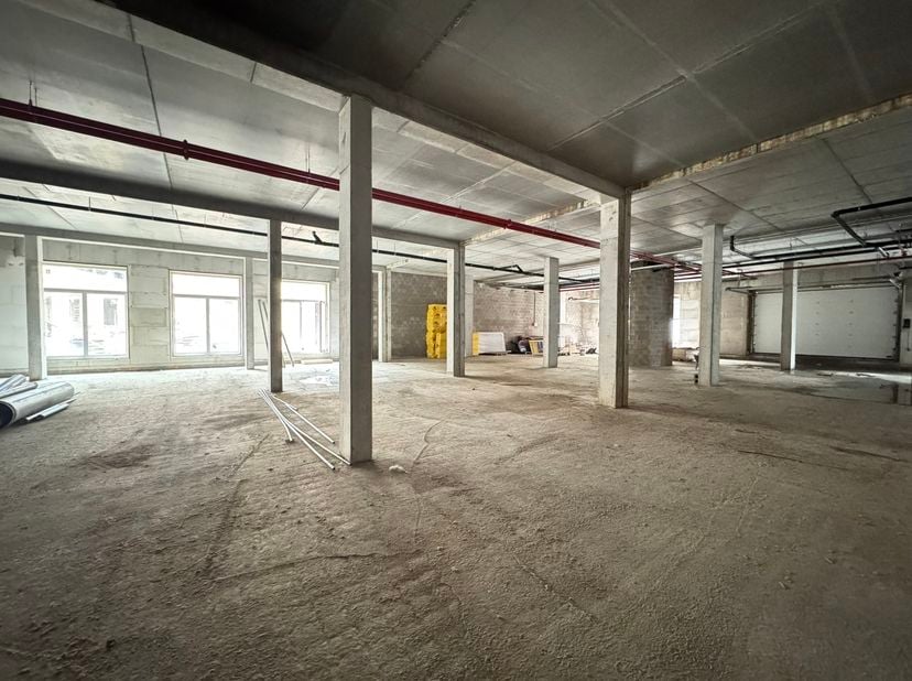 Gelegen in het Tannat-project in het hart van Molenbeek, integreert deze prachtige CASCO commerciële ruimte van 1.231 m² zich in een wijk die volop in