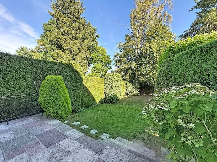 Entre la place Dumon et place Sainte Alix, dans une rue calme et verdoyante, superbe maison 5 chambres de ± 215m² avec grand jardin et garage. Composi