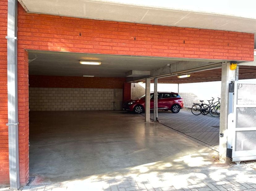 L'emplacement de parking est situé sous un carport et est accessible par un portail sécurisé avec code d'accès, garantissant une sécurité et une intim
