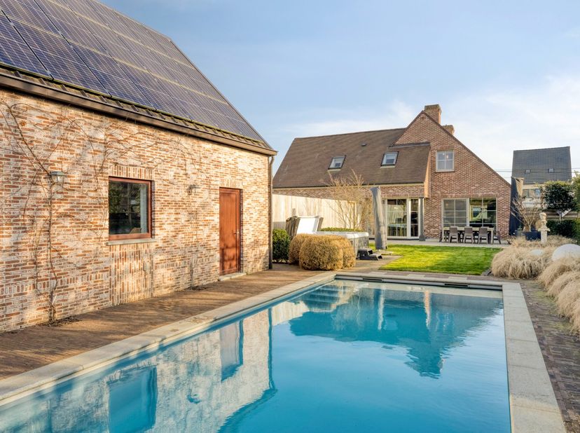 Deze ruime woning is gelegen op een prachtig perceel van 1.474 m² met een praktisch bijgebouw van maar liefst 75 m², een ingebouwd zwembad en een pool