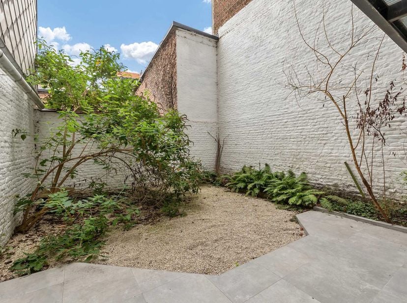 À deux pas du Parvis de Saint-Gilles, du Parc de Forest et du Wiels, nous vous présentons cet élégant sous-plex de ±155m² + jardin. Dès l’entrée, les