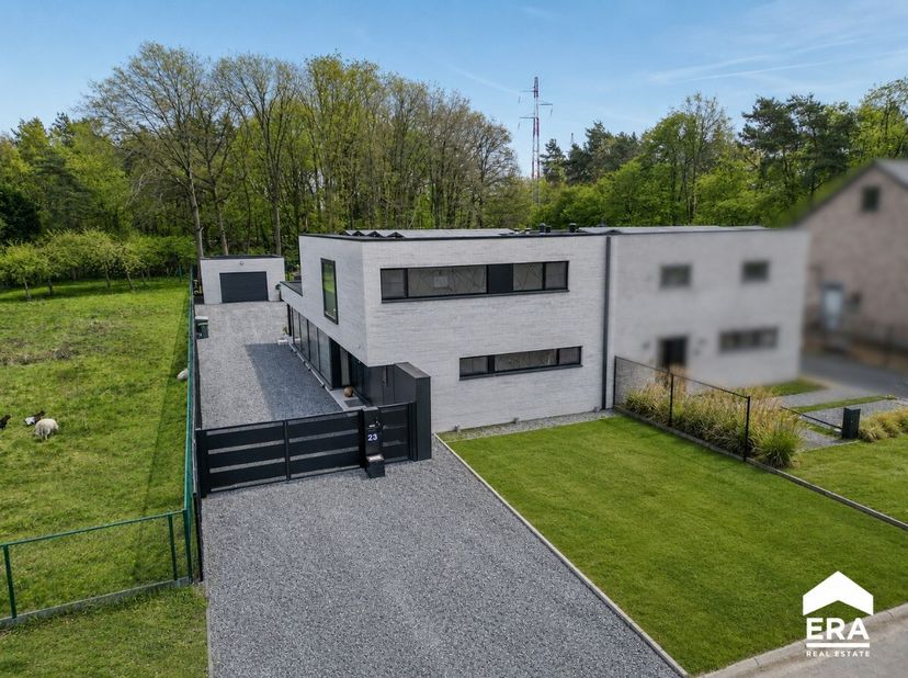 Exclusieve villa uit 2025 met zwembad, en 256 m² wooncomfort in Genk. Deze hoogwaardig afgewerkte villa combineert hedendaagse architectuur met een ru