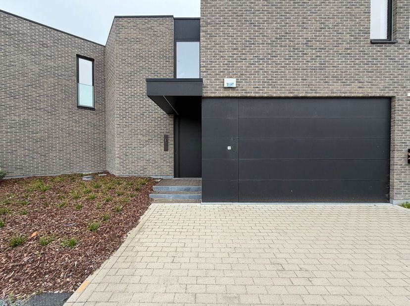 Deze stijlvolle, moderne woning verwelkomt je via een verzorgde inkomhal met ingemaakte kasten, een afzonderlijk gastentoilet en een moderne badkamer