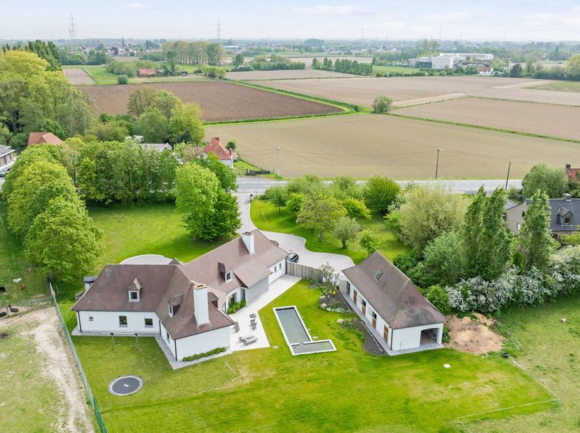 Te midden van het groen bevindt zich dit uitzonderlijke en volledig gerenoveerde (2021) landelijke eigendom, gelegen op een perceel van 13.459 m². Een