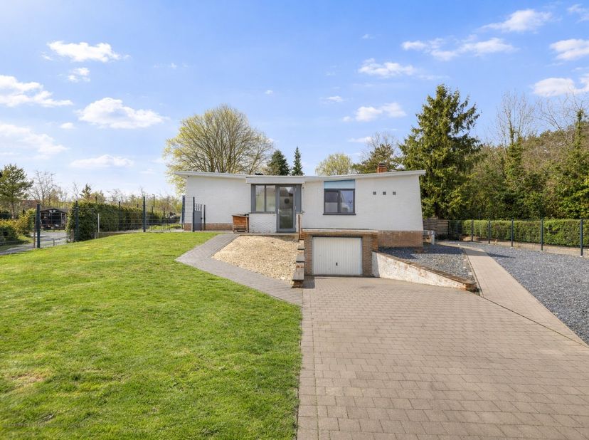 Deze charmante halfopen, gelijkvloerse woning met 2 volwaardige slaapkamers werd gebouwd in 1970 en is gelegen op een mooi perceel van 5a 52ca. Met ee