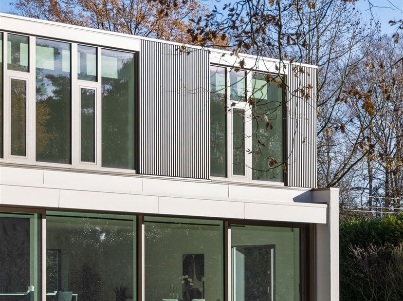 Gelegen aan een met bomen omzoomde laan, straalt deze vernieuwbouwvilla pure rust en verfijning uit. Omringd door groen en grenzend aan de prestigieuz