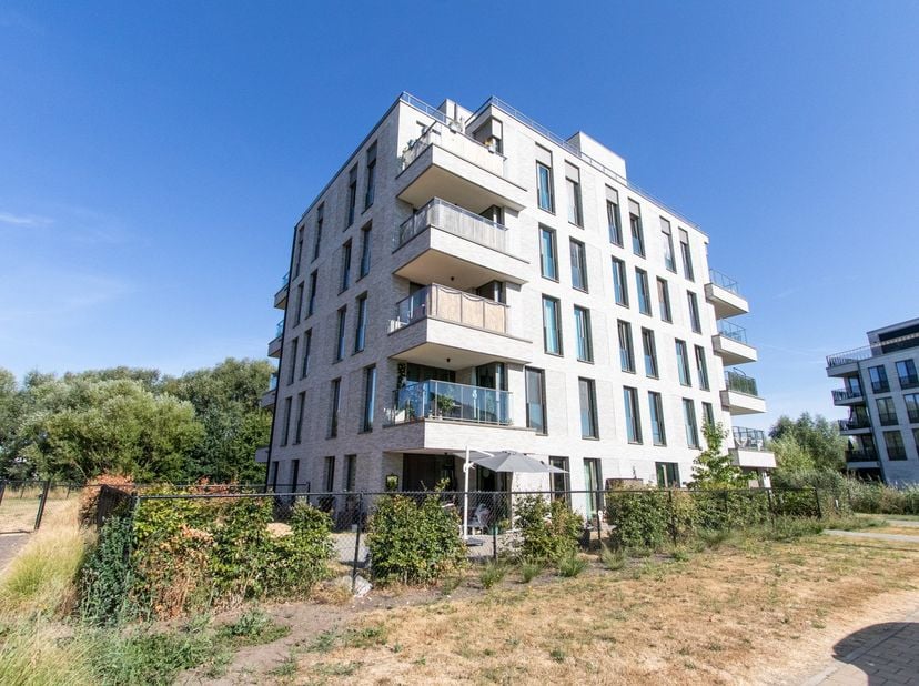 Ruim en hoogwaardig afgewerkt nieuwbouwappartement van 104 m², gelegen op de gelijkvloerse verdieping en voorzien van een aangelegde tuin en terras. H