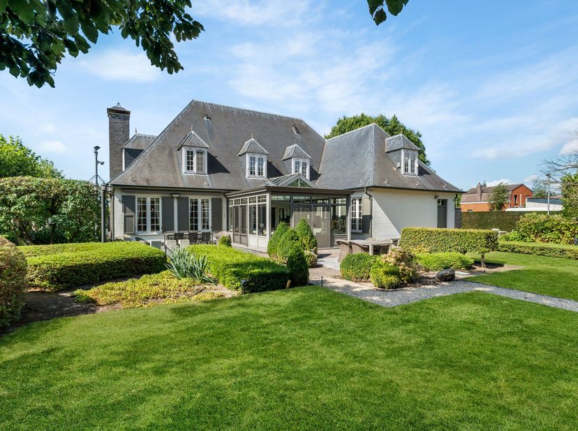 Deze verzorgde villa is gelegen op een groen maar centraal gelegen perceel van +/- 2.081 m². Ze omvat een ruime woonkamer, keuken met veranda, bureau,