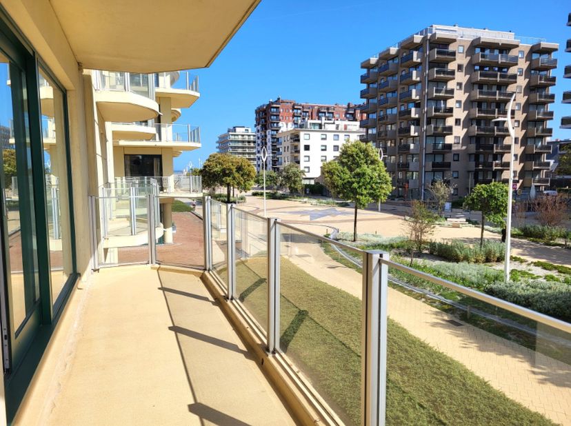 Magnifique appartement d'angle (104 m²) entièrement rénové, bénéficiant d'un emplacement central sur la place de l'Esplanade à La Panne. L'appartement