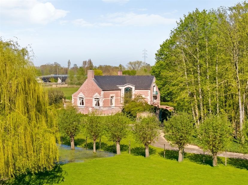 Een uitzonderlijke opportuniteit: exclusieve villa met bos, zicht  en  unieke geschiedenis!   Via een lange oprit in authentieke kinderkopjes bereikt