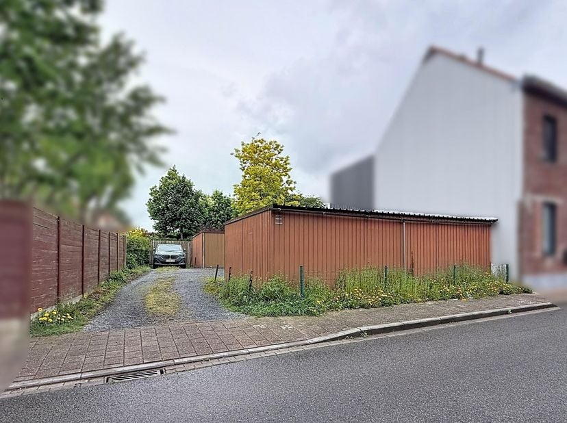 Perceel bouwgrond (voor halfopen bebouwing) met thans 6 erop staande garages. <br />
Het perceel is gelegen in een verkaveling. De verkavelingsverunni