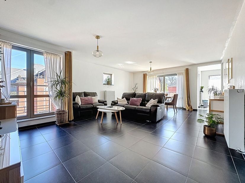 Op de grens met Dilbeek, in een recente en perfect onderhouden residentie, ontdekt u dit prachtige lichtrijke appartement van 115 m² met mooie volumes