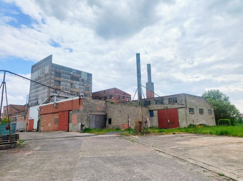 Projet de réaménagement à Herdersem (Alost). Parcelle de 7 458 m² avec habitation et entrepôts. Partiellement située en zone résidentielle.<br />
<br