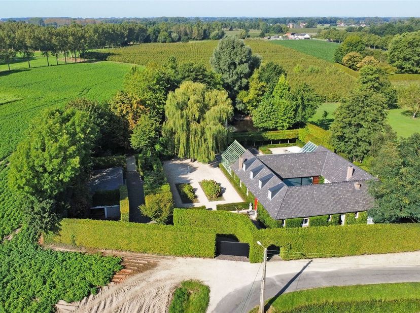 Achter een afgesloten toegangspoort met prachtig aangelegde binnenkoer bevindt zich deze charmante vierkantshoeve, welke door de jaren heen een volled