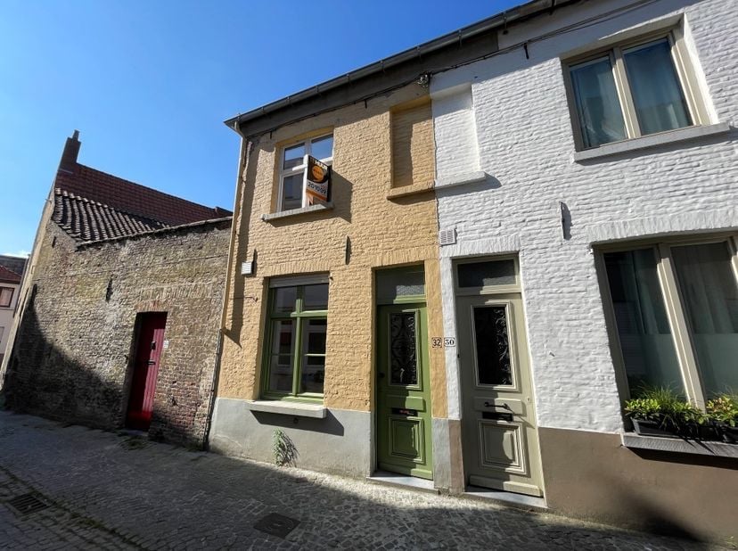 Op een RUSTIGE toplocatie in de BINNENSTAD vinden we deze KNAPPE stadswoning terug. De woning verwelkomt je met een inkomhal voorzien van vestiaire. D