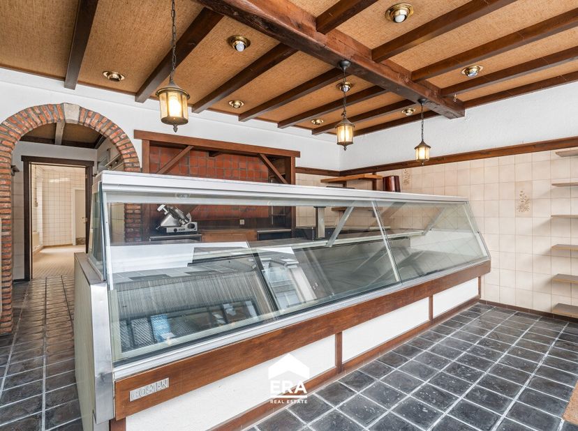 Op een ruim perceel van maar liefst 1.104 m² bevindt zich deze halfopen handelszaak met woonst, centraal gelegen in de dorpskern van Zomergem. Een eig