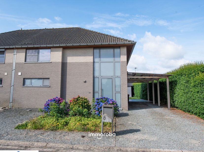 Ideaal gelegen, moderne woning met op het gelijkvloers: inkomhal, gastentoilet, ruime en lichtrijke living met open, volledig ingerichte keuken, bergi