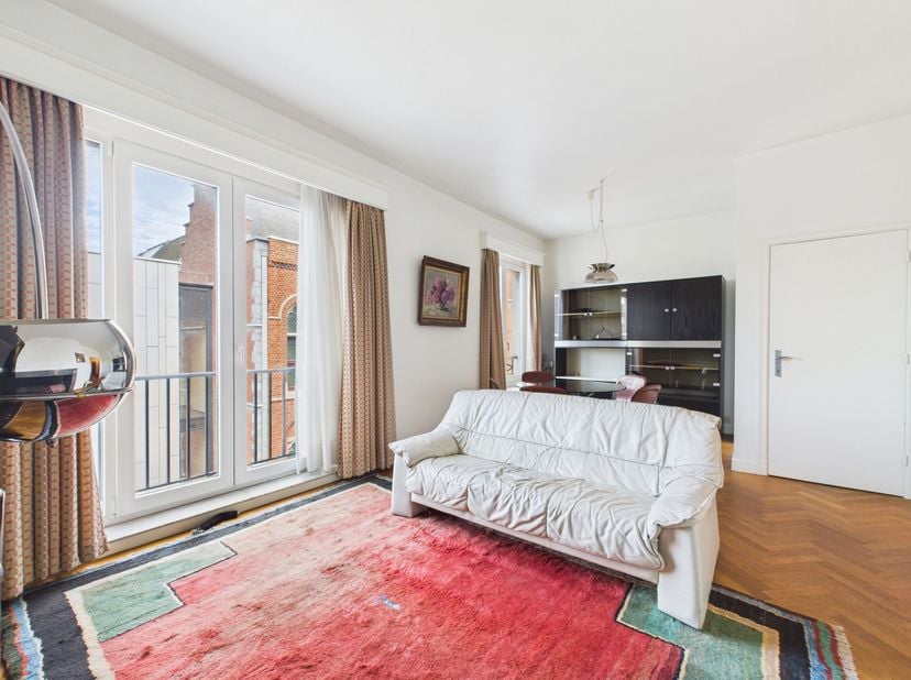 Gelegen in het hart van de stad, op de 2e verdieping van een residentie met lift, biedt dit appartement een praktische indeling: een inkomhal met vest