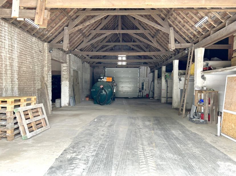 Op een perceel van 1173m² staat deze functionele loods van 450m² met ruime oprit. De loods is uitgerust met een automatische poort van 3,5 meter hoog
