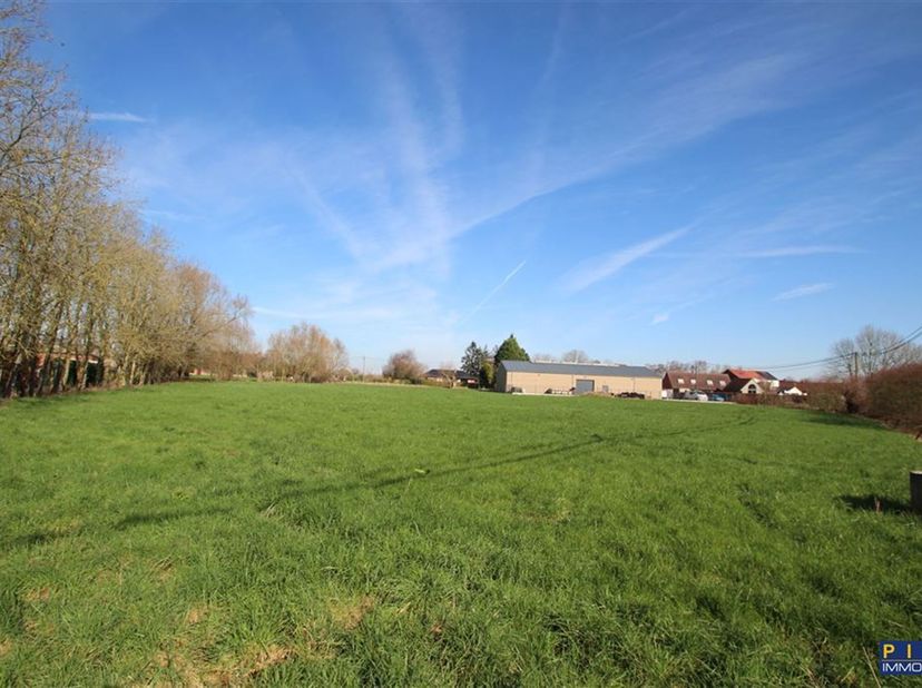 Large terrain à bâtir, situé en zone d'habitat à caractère rural, de  44 ares (4.400 m²), front à rue de 90 mètres idéal pour permis groupé. Descripti