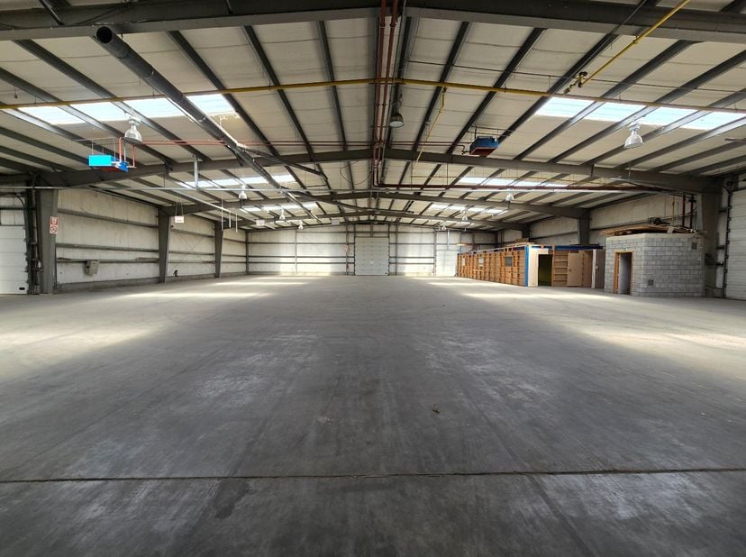 Strategisch gelegen magazijn-/bedrijfsruimte van ca. 1.200 m² met 5 sectionaalpoorten en 3 laadkades. Dankzij de vlotte verbinding met de omliggende i